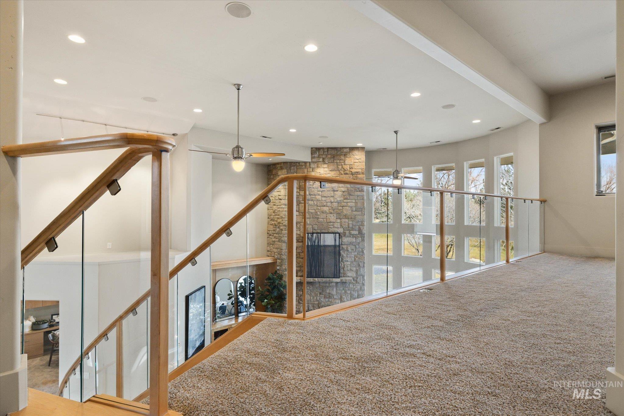 1400 North Razza Way Eagle, ID 83616 - Photo 27 of 50 Unfurnished living room featuring a stone fireplace, carpet floors, recessed lighting, and ceiling fan