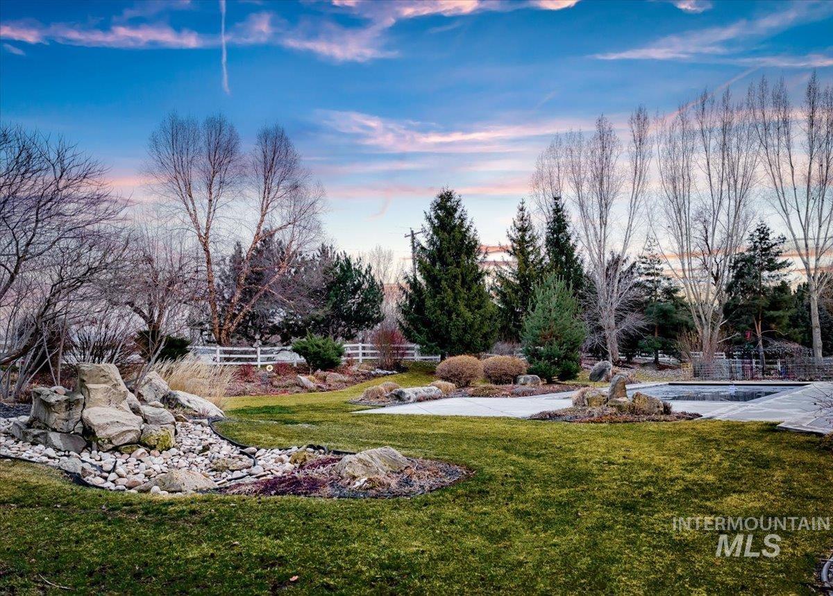 1400 North Razza Way Eagle, ID 83616 - Photo 43 of 50 Yard at dusk featuring a yard and an outdoor pool