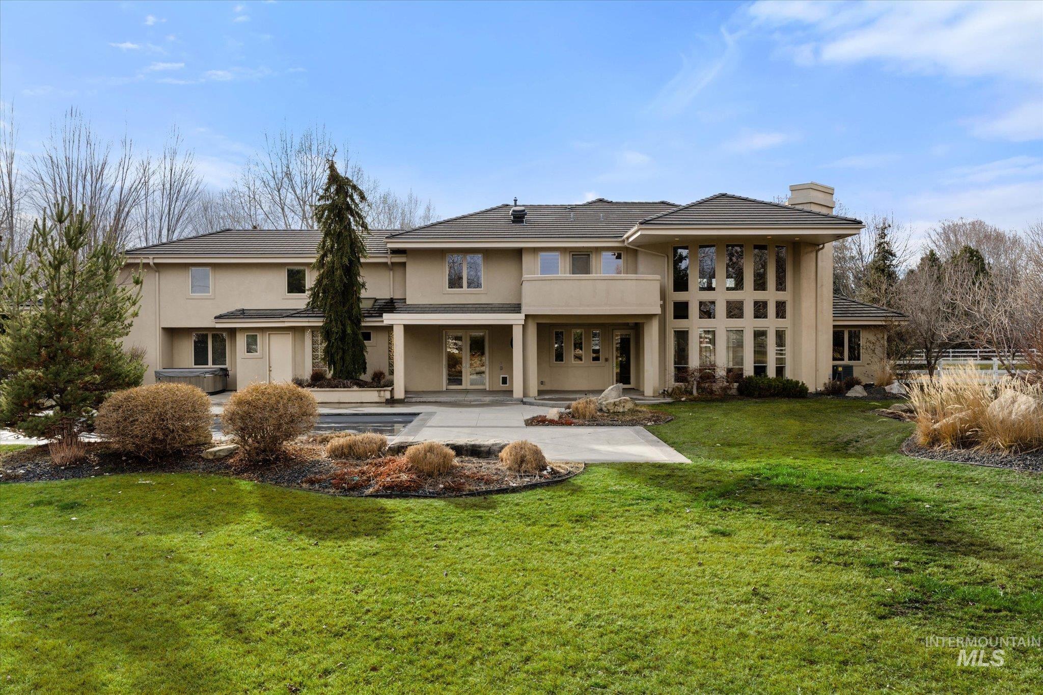 1400 North Razza Way Eagle, ID 83616 - Photo 45 of 50 Back of property featuring a chimney, stucco siding, a patio, a yard, and french doors