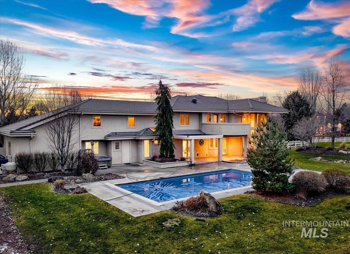 1400 North Razza Way Eagle, ID 83616 - Photo 5 of 50 Back of property at dusk with a patio area, a yard, an outdoor pool, and stucco siding