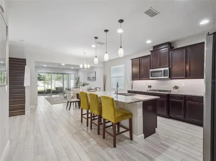 a kitchen with a table chairs refrigerator and cabinets