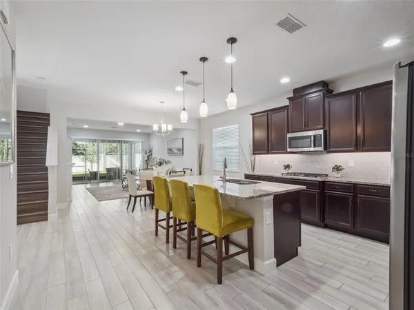 a kitchen with a table chairs refrigerator and cabinets