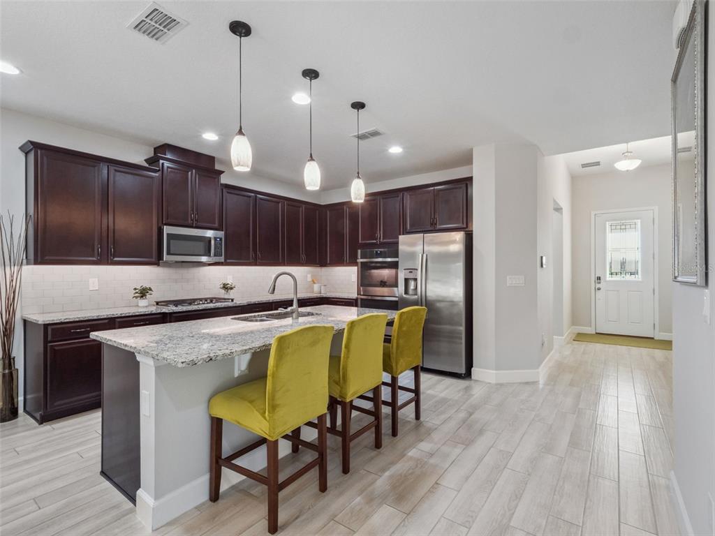 14345 Wabasso Loop Winter Garden, FL 34787 - Photo 5 of 31 a kitchen with a table chairs refrigerator and cabinets