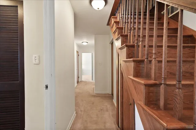 a view of staircase with railing and white walls