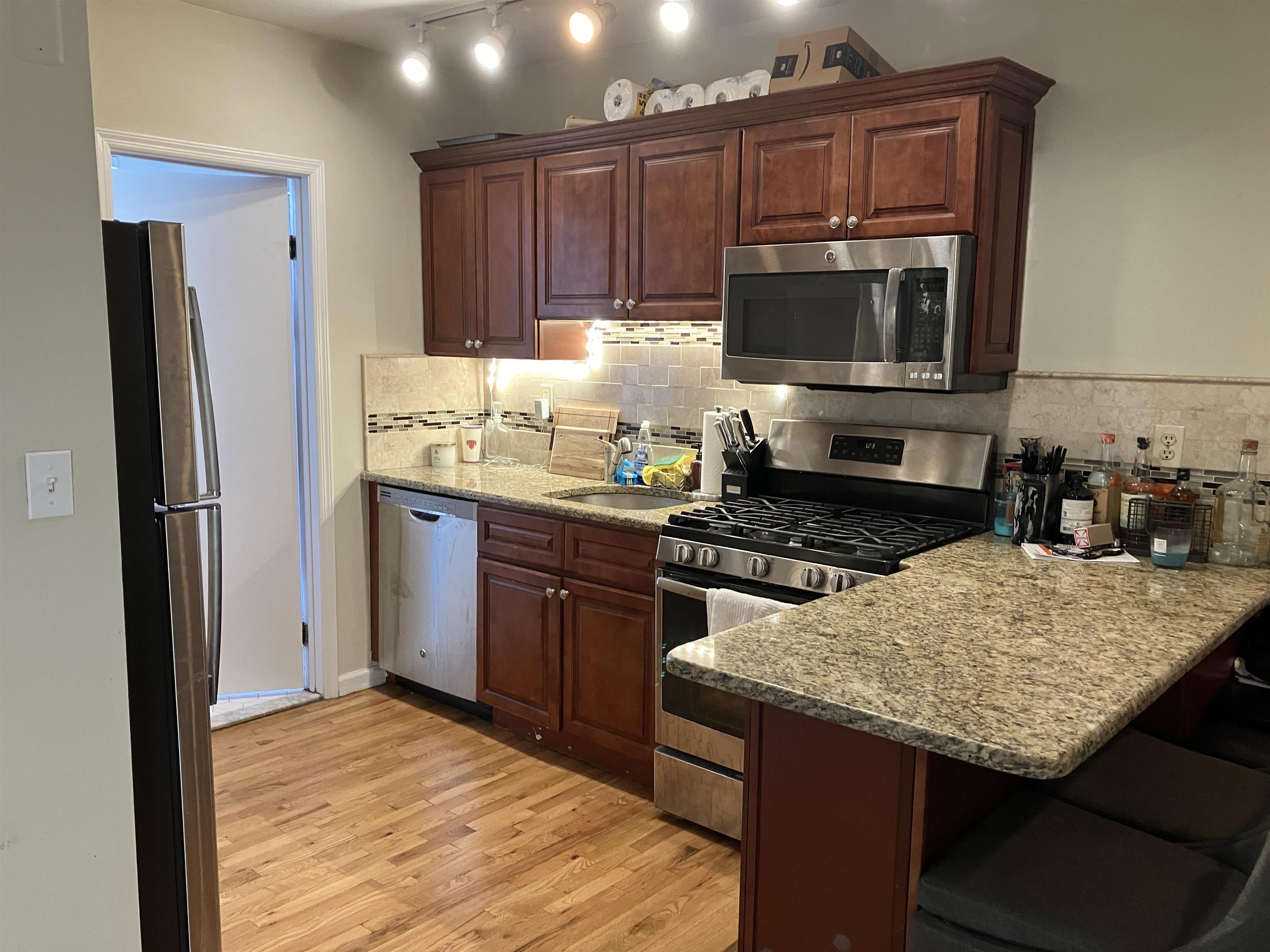 409 Adams Street, Unit 8 Hoboken, NJ 07030 - Photo 7 of 17 a kitchen with a sink stove and refrigerator