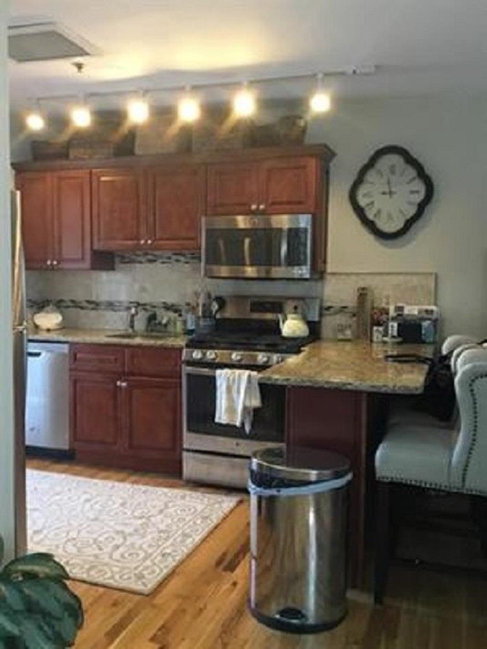 409 Adams Street, Unit 8 Hoboken, NJ 07030 - Photo 8 of 17 a kitchen with a stove and a microwave