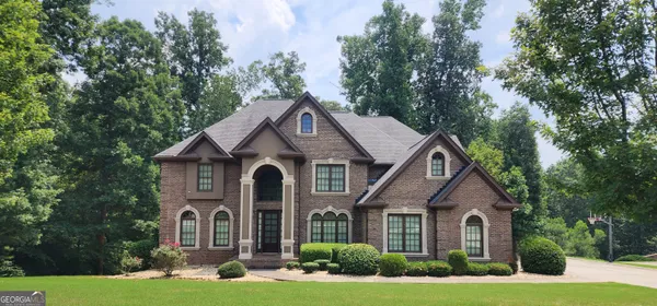 a front view of a house with yard and green space