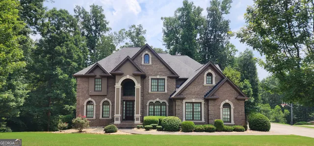 a front view of a house with yard and green space