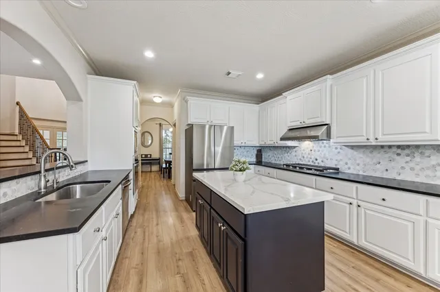 a kitchen with stainless steel appliances granite countertop a sink stove and refrigerator