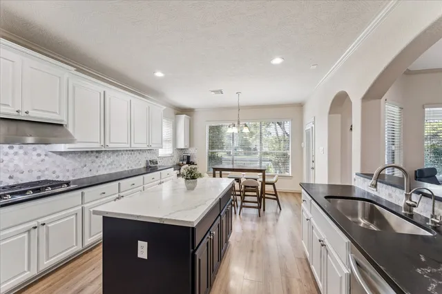 a kitchen with granite countertop a sink stove and cabinets