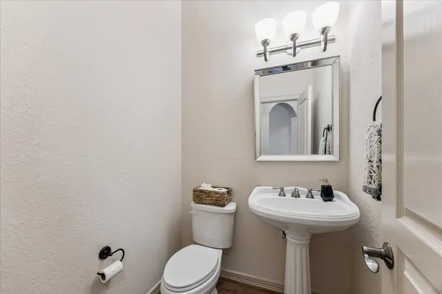 a bathroom with a sink mirror and toilet