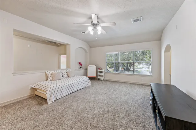 a spacious bedroom with a bed and a window