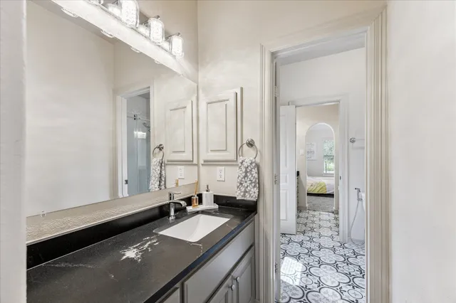 a bathroom with a granite countertop sink a mirror and a shower