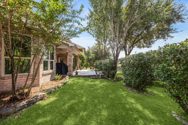 a view of a backyard with a table and chairs and a large tree