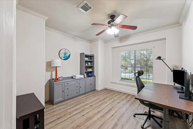 a view of a workspace with furniture and a window