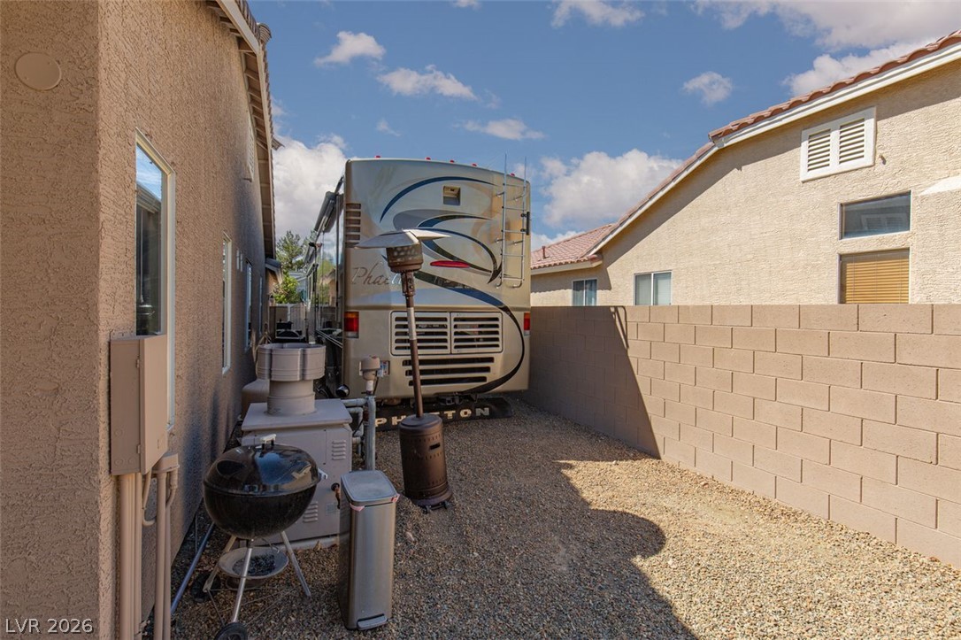 4670 Los Rancheros Avenue Las Vegas, NV 89129 - Photo 48 of 57 Gravel side yard features a tall privacy block wall and space for outdoor storage.