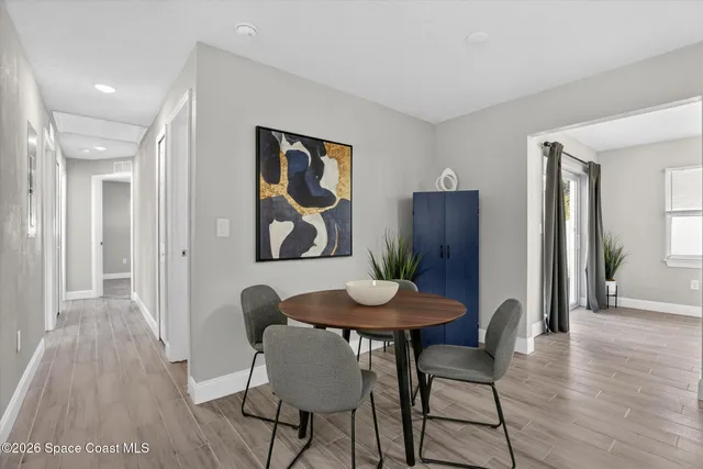 an empty room with wooden floor and a hallway