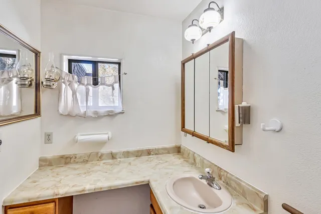 a bathroom with a granite countertop sink and a mirror