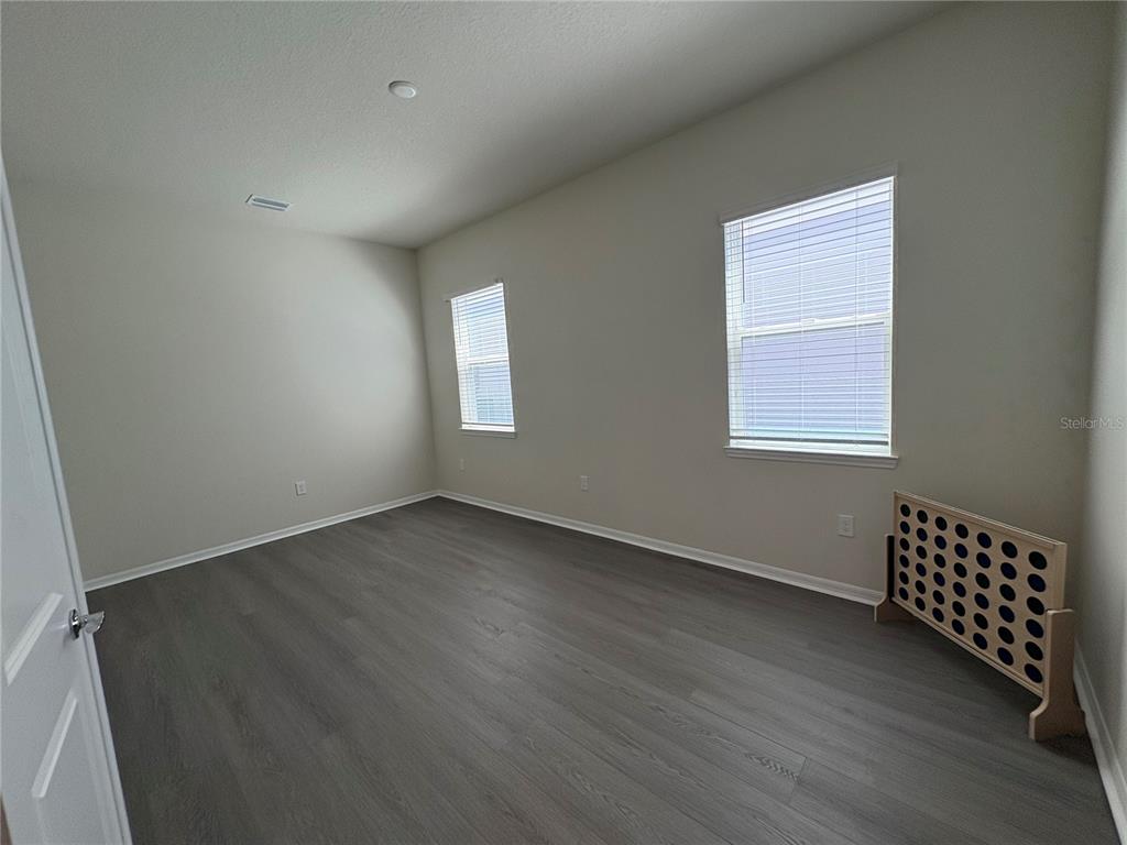 8243 Fenton Street Orlando, FL 32836 - Photo 23 of 35 an empty room with wooden floor cabinet and windows