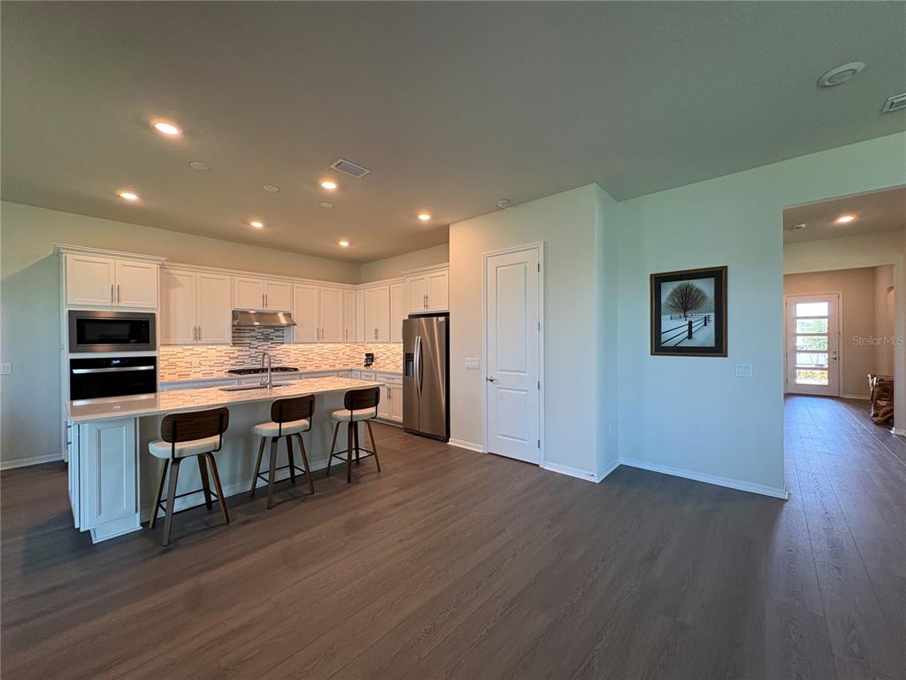 8243 Fenton Street Orlando, FL 32836 - Photo 4 of 35 a open kitchen with kitchen island a refrigerator stove a sink and a oven