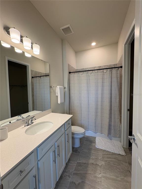 8243 Fenton Street Orlando, FL 32836 - Photo 10 of 35 a bathroom with a sink a toilet a mirror and shower