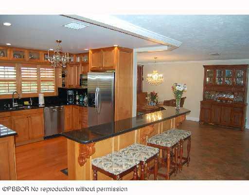 12 Ridge Boulevard Ocean Ridge, FL 33435 - Photo 6 of 13 a kitchen with stainless steel appliances kitchen island granite countertop a refrigerator a stove and a sink