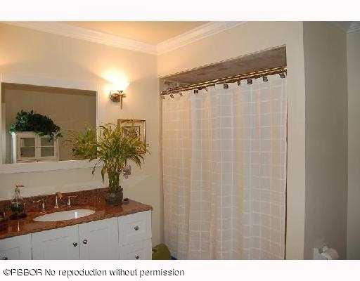 12 Ridge Boulevard Ocean Ridge, FL 33435 - Photo 10 of 13 a bathroom with a granite countertop sink a mirror and shower