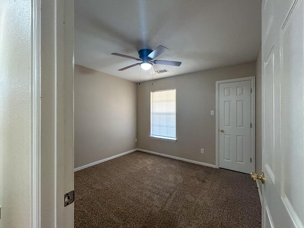 1010 Turkey Creek Court, Unit B Bridgeport, TX 76426 - Photo 6 of 10 a view of an empty room with a ceiling fan and a window