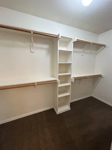 a view of walk in closet with empty racks