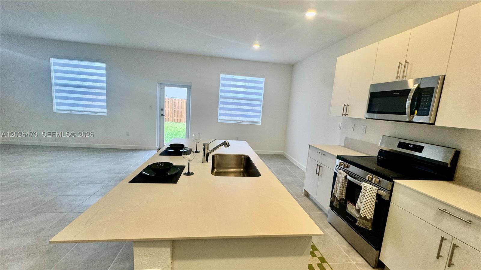 19479 Southwest 340th Street, Unit 1 Homestead, FL 33034 - Photo 41 of 58 a kitchen with a sink a microwave and cabinets