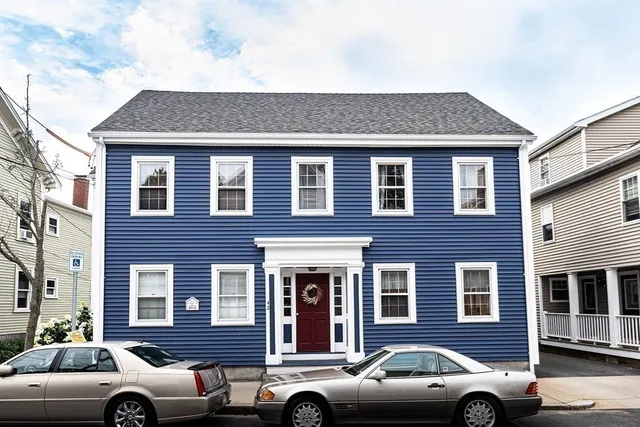 a front view of a house with a parking space
