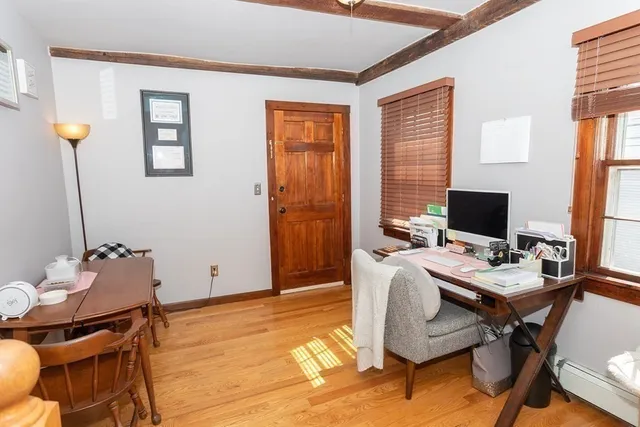 a view of a workspace with furniture and a window