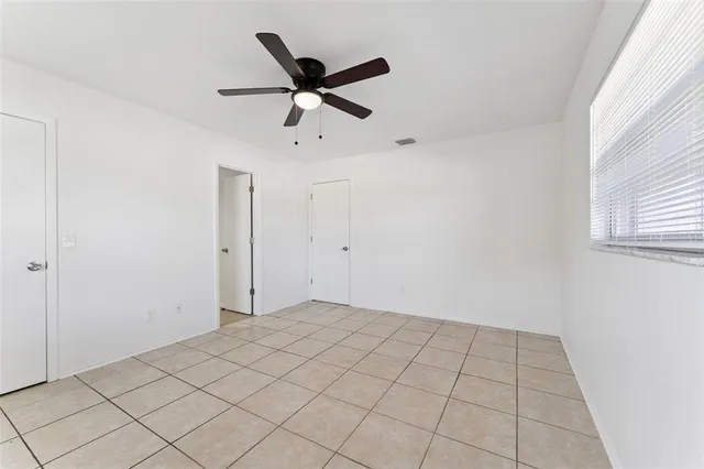 a view of a room with a ceiling fan and window
