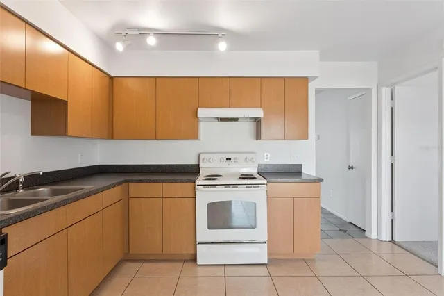 a kitchen with a stove sink and cabinets
