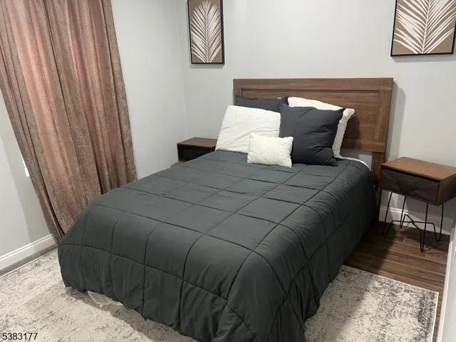 a bedroom with a bed and painting on the wall