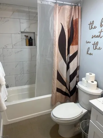 a white toilet sitting next to a bathroom sink and a bathtub