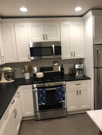 a kitchen with stainless steel appliances granite countertop a stove a sink and a microwave