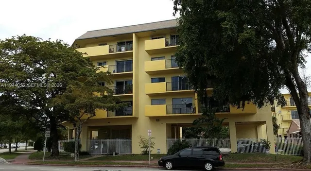 a front view of a building and car parked