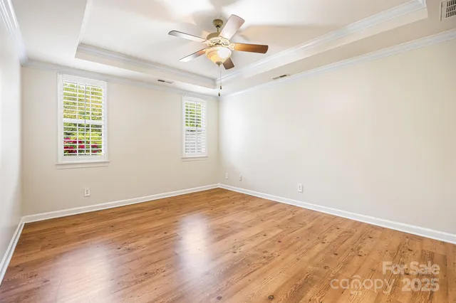 an empty room with a window and a ceiling fan