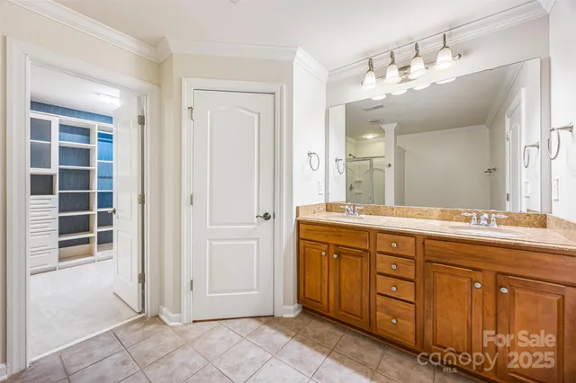a spacious bathroom with a double vanity sink a large mirror and a shower