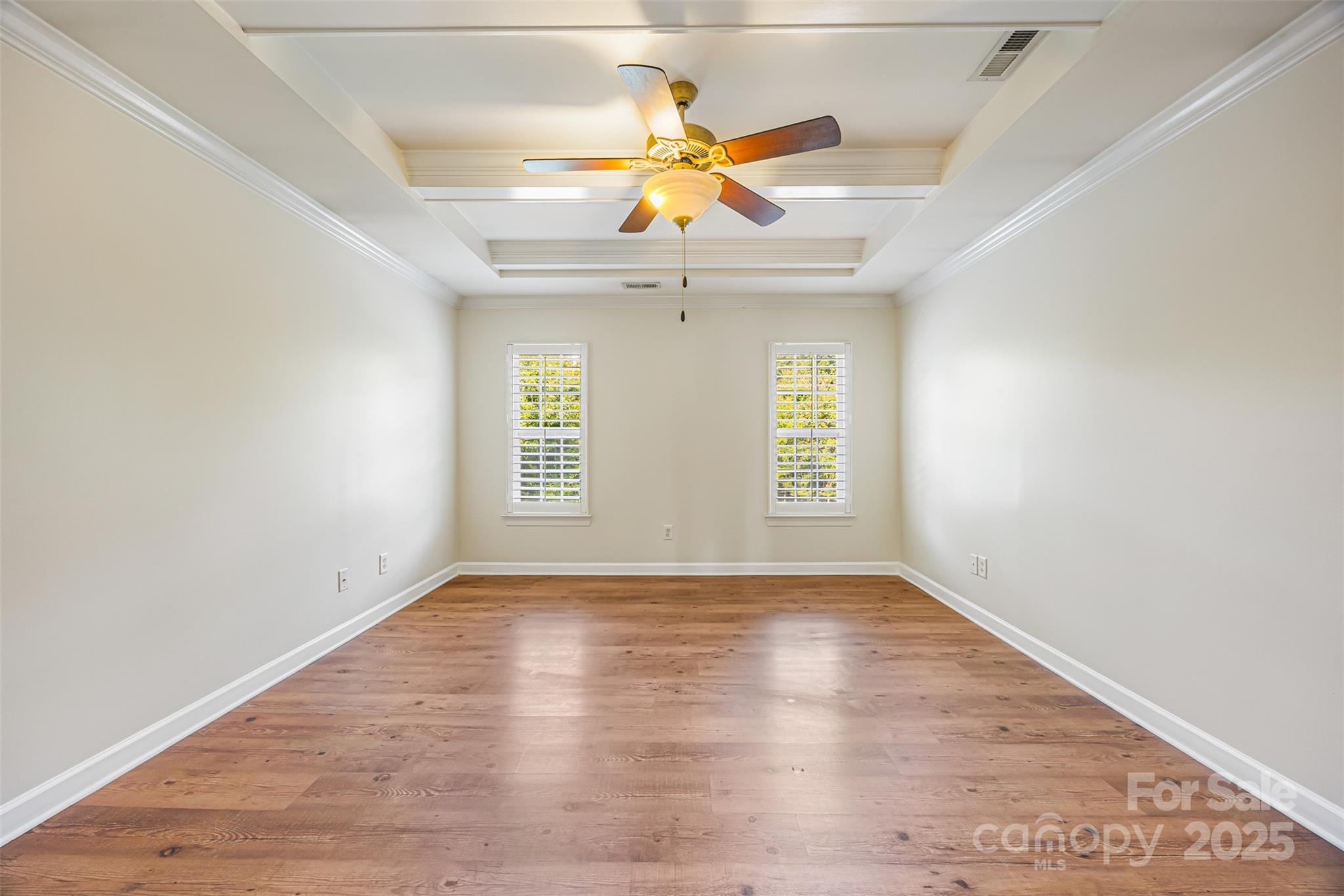 6729 Dusty Saddle Road Charlotte, NC 28277 - Photo 31 of 44 an empty room with wooden floor chandelier fan and windows