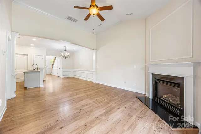 a view of empty room with wooden floor and fireplace