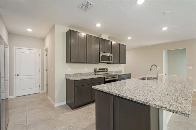 a view of kitchen with kitchen island and stainless steel appliances