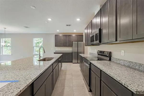 a kitchen with kitchen island granite countertop stainless steel appliances and cabinets