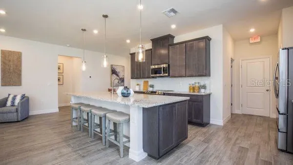a kitchen with stainless steel appliances granite countertop a sink stove microwave and refrigerator