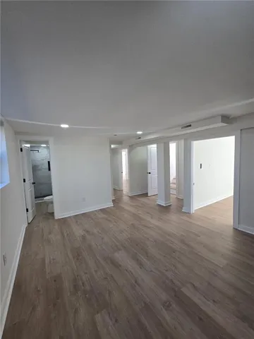 a view of a big room with wooden floor and windows