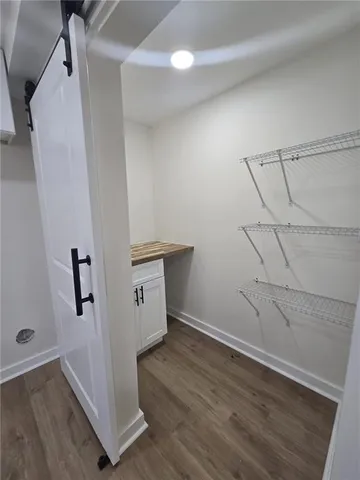 an empty room with wooden floor and white walls