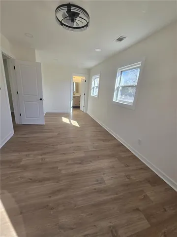 a view of empty room with wooden floor