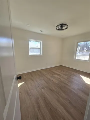 a view of empty room with window and hardwood floor