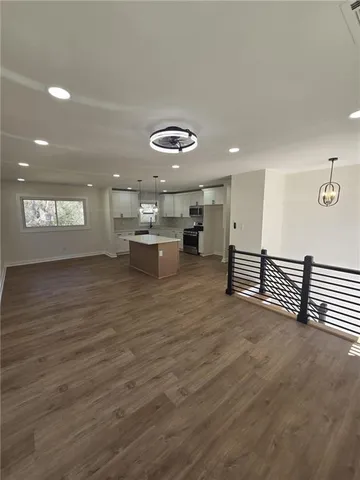 a view of kitchen with kitchen island sink refrigerator and window